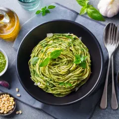 Pyszny obiad bez mięsa: spaghetti z pesto, świeżą bazylią, orzeszkami pinii i parmezanem.
