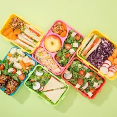 Kolorowe pojemniki z pysznym lunch do pracy: kanapki, sałatki, ryż, owoce i warzywa.