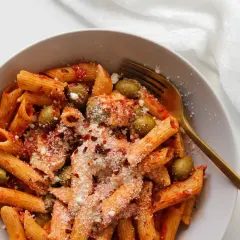 Penne z sosem pomidorowym, oliwkami i startą mozzarellą, posypane płatkami chili. Idealny makaron z mozzarellą na szybki obiad.