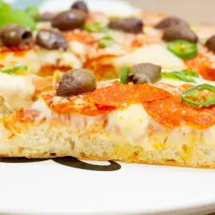 Pyszna pizza z patelni z pikantnym salami, oliwkami i papryczką. Idealna na szybki obiad.
