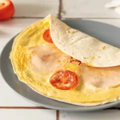Pyszna, ciepła kolacja: omlet z tortillą, pomidorkami i szynką. Idealny na szybki posiłek.