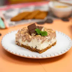 Pyszne ciasto Kinder Country na białym talerzyku, ozdobione czekoladą i miętą.
