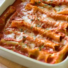 Pyszne cannelloni ze szpinakiem, zapieczone pod sosem pomidorowym i ciągnącym się serem. Idealne na rodzinny obiad.
