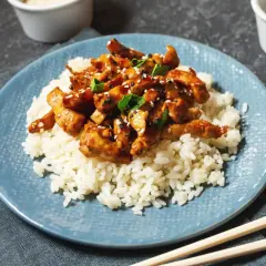 Pyszny kurczak w sosie teriyaki, podany na białym ryżu, posypany sezamem i szczypiorkiem. Idealny posiłek na szybki obiad.