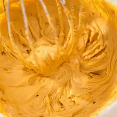 Kremowy, złocisty mus do ciasta z mascarpone, ubijany trzepaczką miksera.