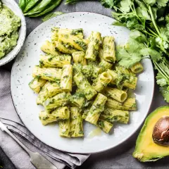 Pyszny makaron z pesto, podany z awokado i świeżymi ziołami. Idealny na szybki obiad.