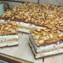 Pyszny snickers bez pieczenia z warstwami kremu, czekolady i orzeszków ziemnych. Idealny deser na każdą okazję.