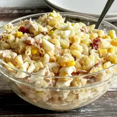 Pyszna sałatka z tuńczykiem i makaronem, jajkiem i kukurydzą w szklanej misce. Idealna na szybki lunch.
