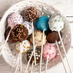 Kolorowe cake pops w białym koszyku, idealne na przyjęcie. Prosty przepis na te słodkie przysmaki.