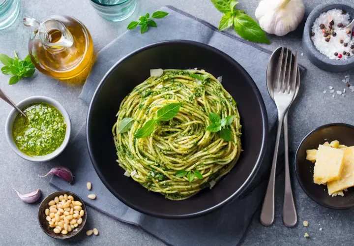 Pyszny obiad bez mięsa: spaghetti z pesto, świeżą bazylią, orzeszkami pinii i parmezanem.