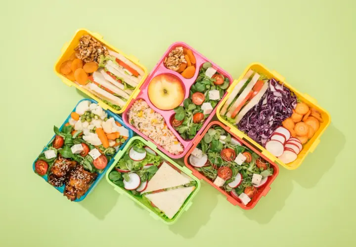 Kolorowe pojemniki z pysznym lunch do pracy: kanapki, sałatki, ryż, owoce i warzywa.