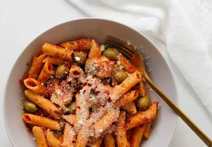 Penne z sosem pomidorowym, oliwkami i startą mozzarellą, posypane płatkami chili. Idealny makaron z mozzarellą na szybki obiad.