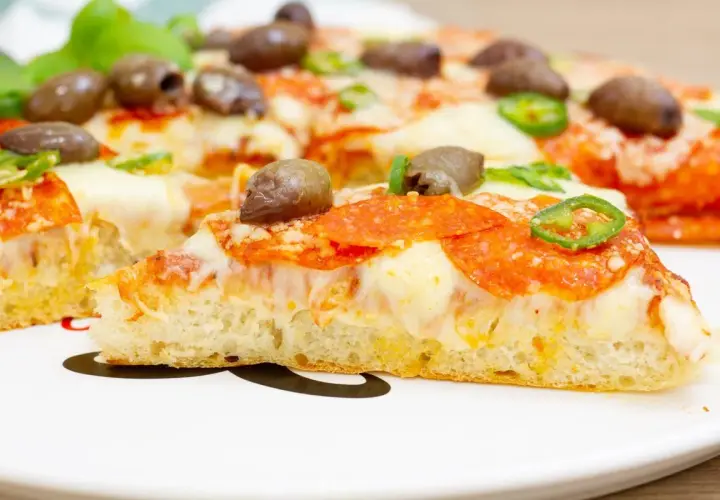 Pyszna pizza z patelni z pikantnym salami, oliwkami i papryczką. Idealna na szybki obiad.