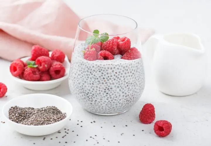 Pyszny deser z chia z malinami i miętą, przygotowany z nasion chia, mleka i świeżych owoców.