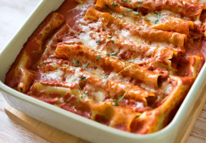 Pyszne cannelloni ze szpinakiem, zapieczone pod sosem pomidorowym i ciągnącym się serem. Idealne na rodzinny obiad.