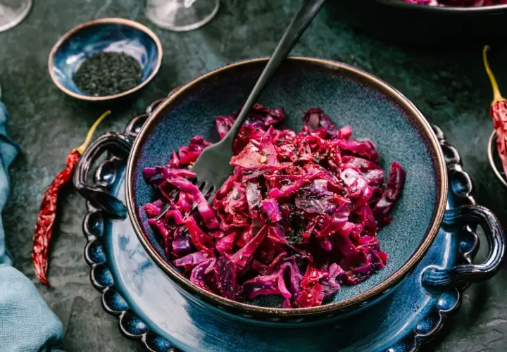 Aksamitna surówka z czerwonej kapusty, doprawiona czarnym sezamem i papryczkami chili, czeka na widelcu.