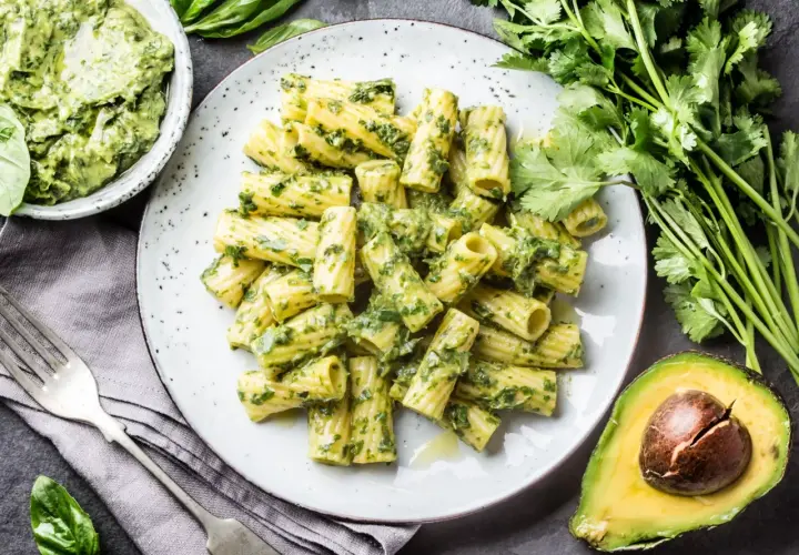 Pyszny makaron z pesto, podany z awokado i świeżymi ziołami. Idealny na szybki obiad.