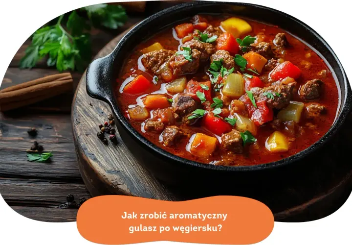 Aromatyczny gulasz po węgiersku w czarnym naczyniu, z widocznymi kawałkami mięsa, papryki i ziemniaków.