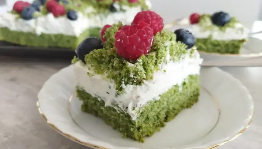 Zielony biszkopt z kremem mascarpone, udekorowany malinami i borówkami. Pyszne ciasto leśny mech z mascarpone.