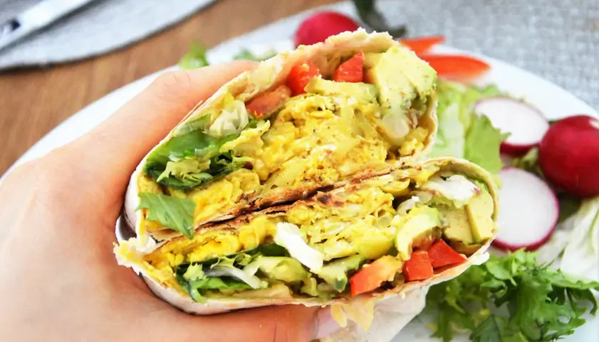 Pyszna tortilla z jajecznicą, awokado i warzywami, idealna na szybkie śniadanie.