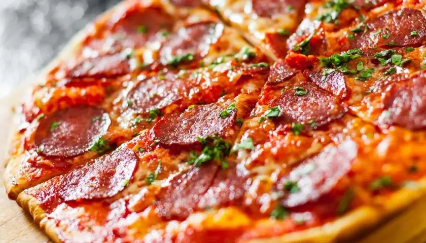 Pyszna pizza bez drożdży z pikantnym salami i posypką z ziół. Idealna na szybki obiad.