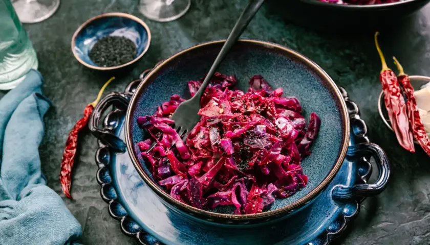 Aksamitna surówka z czerwonej kapusty, doprawiona czarnym sezamem i papryczkami chili, czeka na widelcu.