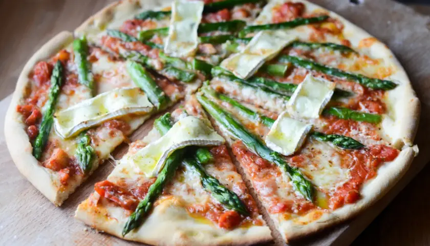 Pyszna pizza ze szparagami i serem brie, z sosem pomidorowym i ciągnącym się serem. Idealna na wiosenny obiad.