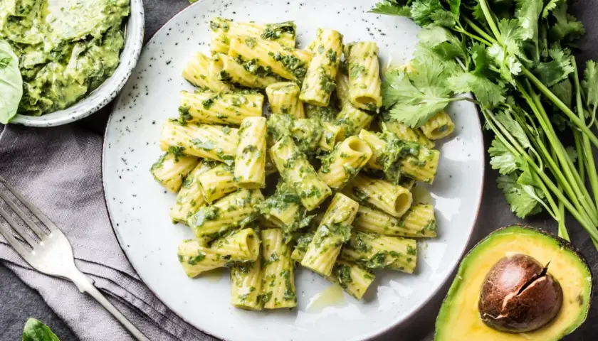 Pyszny makaron z pesto, podany z awokado i świeżymi ziołami. Idealny na szybki obiad.