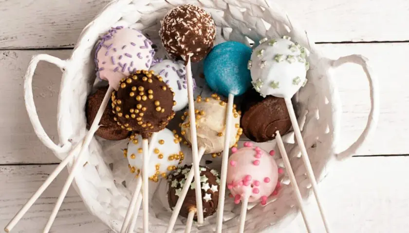 Kolorowe cake pops w białym koszyku, idealne na przyjęcie. Prosty przepis na te słodkie przysmaki.