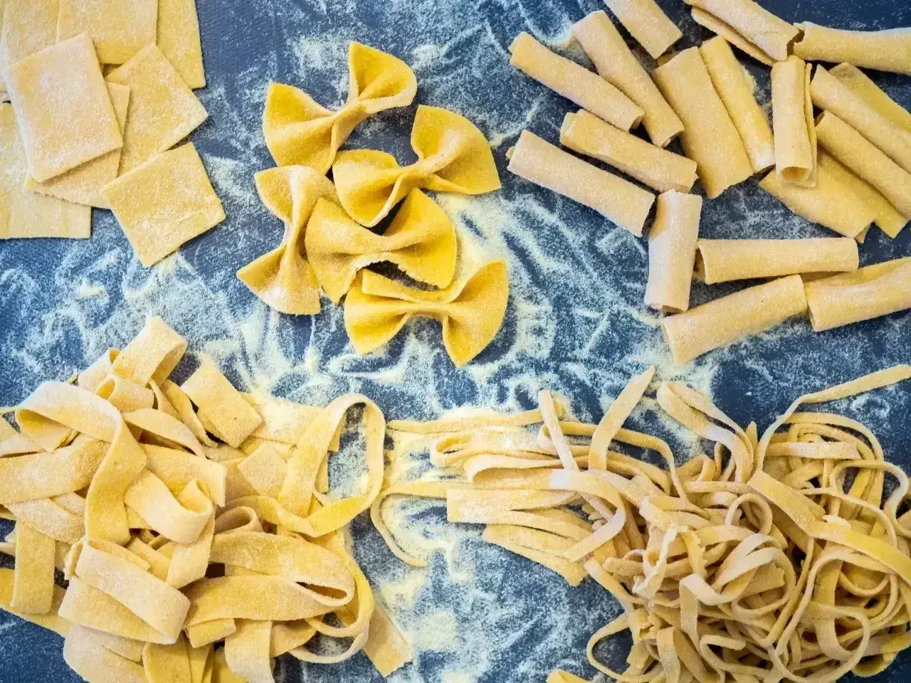 Różne rodzaje świeżego makaronu: kwadraty, kokardki, rurki i wstążki. Idealne, by dowiedzieć się, jak ugotować makaron.