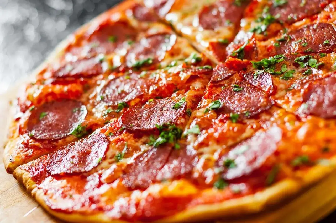 Pyszna pizza bez drożdży z pikantnym salami i posypką z ziół. Idealna na szybki obiad.