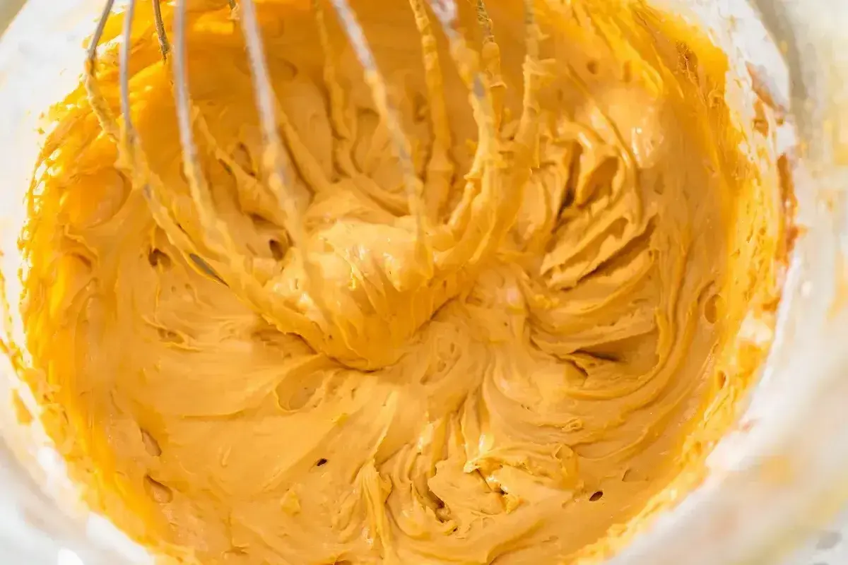 Kremowy, złocisty mus do ciasta z mascarpone, ubijany trzepaczką miksera.