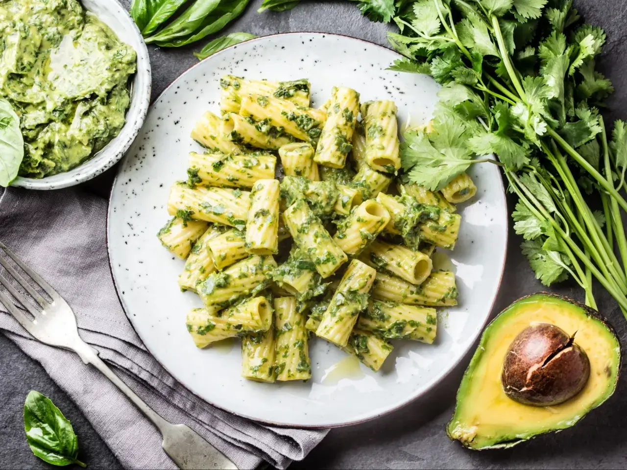 Pyszny makaron z pesto, podany z awokado i świeżymi ziołami. Idealny na szybki obiad.
