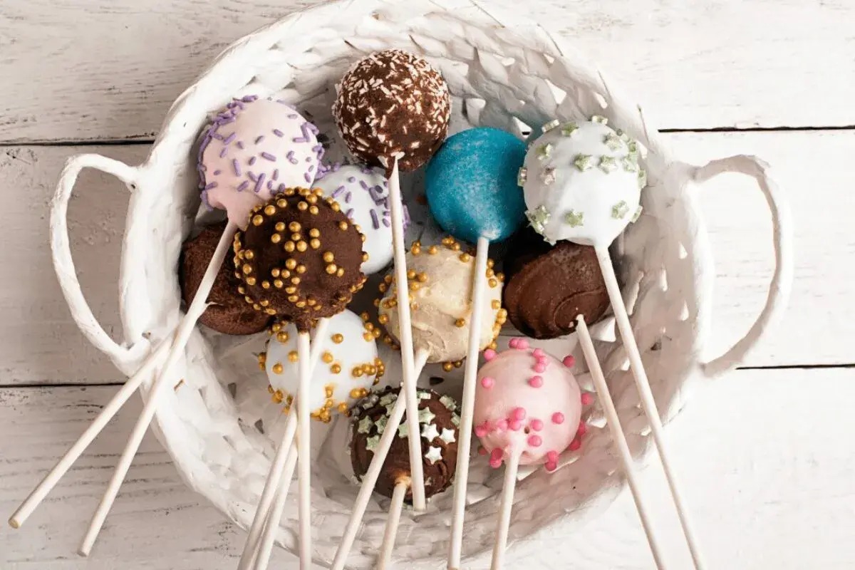 Kolorowe cake pops w białym koszyku, idealne na przyjęcie. Prosty przepis na te słodkie przysmaki.