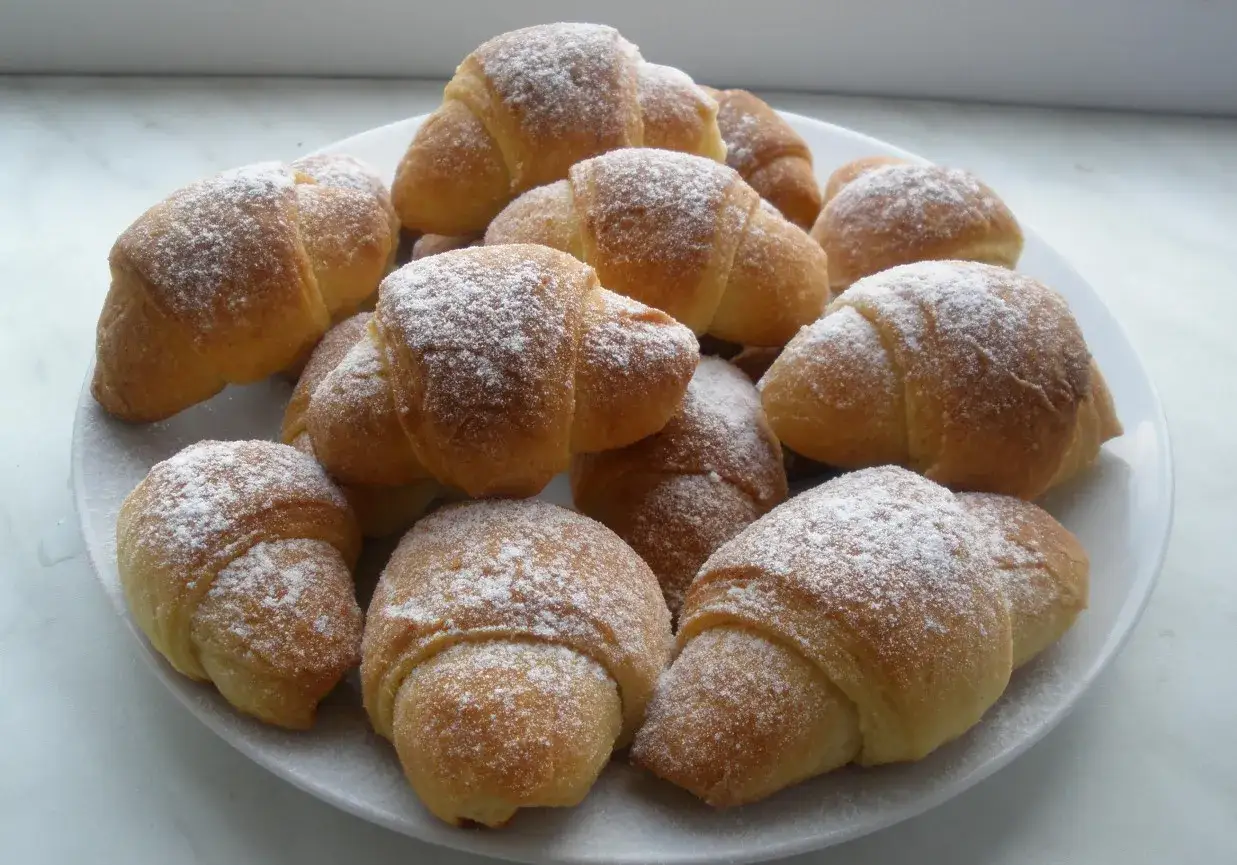 Stosik pysznych, domowych rogalik&oacute;w z marmoladą, posypanych cukrem pudrem. Idealne na deser!